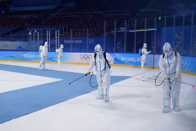 Workers disinfect the ice rink after the women's gold medal hockey game at the 2022 Winter Olympics, Thursday, February 17, 2022, in Beijing. (Photo by Jae C. Hong/AP Photo)