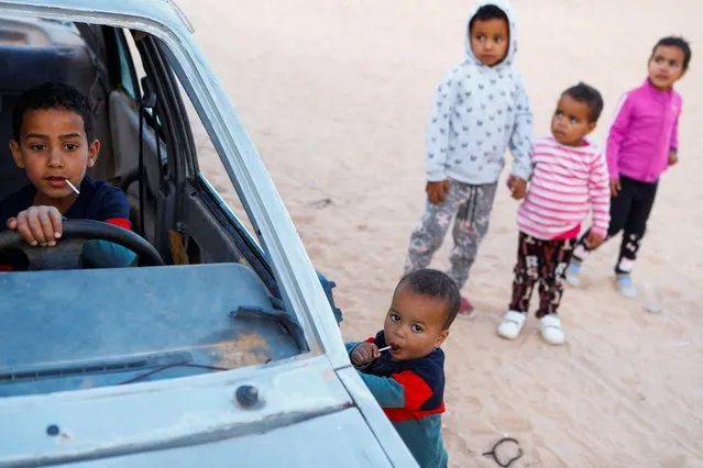 Sahrawi children play in an old car on a street in the Smara refugee camp in Tindouf, Algeria, February 18, 2022. (Photo by Borja Suarez/Reuters)