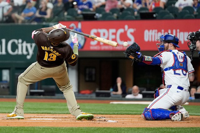 San Diego Padres' Manny Machado (13) falls backwards avoiding a close, inside pitch thrown by Texas Rangers' Jon Gray as catcher Jonah Heim bobbles the throw in the first inning of a baseball game Wednesday, July 3, 2024 in Arlington, Texas. (Photo by Tony Gutierrez/AP Photo)