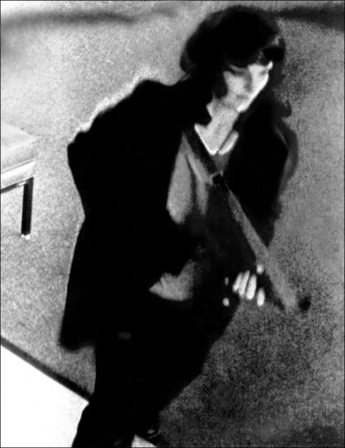 This file photo of a picture released by the FBI and taken from a security camera shows Patricia Hearst, granddaughter of American tycoon Randolph Hearst, during a bank robbery in San Francisco 17 April 1974. Former US President Bill Clinton pardoned Hearst hours before he left office 21 January 2001. Hearst, who was kidnapped 04 February 1974 by the radical Symbionese Liberation Army, claimed she was brainwashed by her kidnappers into helping them rob the bank. (Photo by AFP Photo/Stringer)