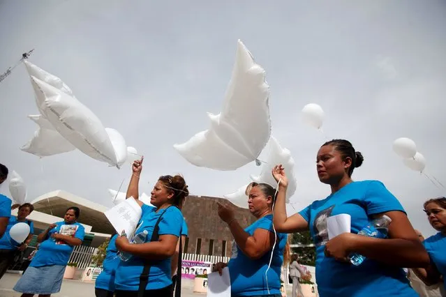 Mothers of missing women hold white balloons, in the shape of doves, during a protest outside a court in Ciudad Juarez, Mexico, July 14, 2015. Relatives and family members are protesting just hours before a court issued its verdict on six men accused of the disappearance and murder of 11 women, who were forced into prostitution, and whose bodies were found at El Navajo creek, local media reported. (Photo by Jose Luis Gonzalez/Reuters)
