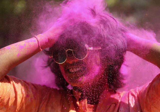 A reveller smeared in colored powder dances during Holi festival in Hyderabad, India, Friday, March 18, 2022. Holi also heralds the arrival of spring. (Photo by Mahesh Kumar A./AP Photo)