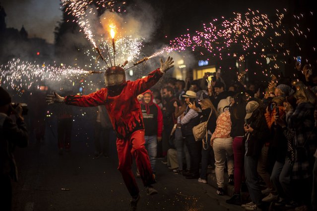 A participant performs during the Fire Parade as part of the “Nit de la Crema” (Fire Night) of the Fallas Festival in Valencia, eastern Spain, 19 March 2023. The Fallas festival is a fortnight-long fiesta in which installations of parodic papier-mache, cardboard, and wooden sculptures are traditionally burnt every year on the last day of the event (usually on 19 March) in the so-called 'Crema' to end the festivities. (Photo by Biel Alino/EFE)