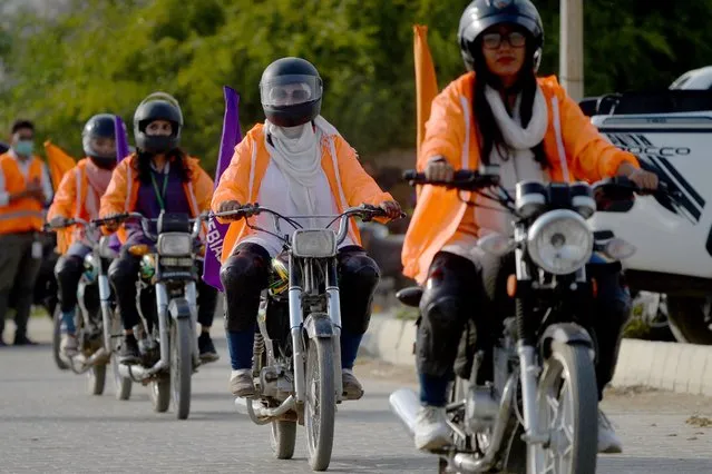 Participants of Women on Wheels (WOW) ride their motorbikes to mark International Women's Day in Karachi on March 7, 2022. (Photo by Rizwan Tabassum/AFP Photo)