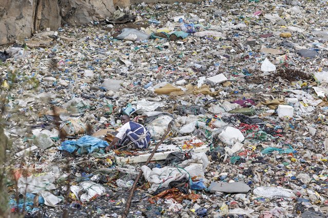 A volunteer searches through a rubbish dump for human remains at Mukuru slum in Nairobi on July 14, 2024. Eight female bodies have been recovered so far from a dumpsite in a Nairobi slum. The mutilated and dismembered bodies, trussed up in plastic bags, were hauled out of a sea of floating rubbish in the abandoned quarry. Police chiefs said they were pursuing possible links to cults, serial killers or rogue medical practitioners in their investigation into the macabre saga, which has horrified and angered the nation. (Photo by Tony Karumba/AFP Photo)