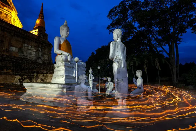 Buddhists carry candles as they pray during Vesak Day, an annual celebration of Buddha's birth, enlightenment and death, at Wat Yai Chai Mongkhon temple in Ayutthaya, Thailand on May 10, 2017. (Photo by Athit Perawongmetha/Reuters)