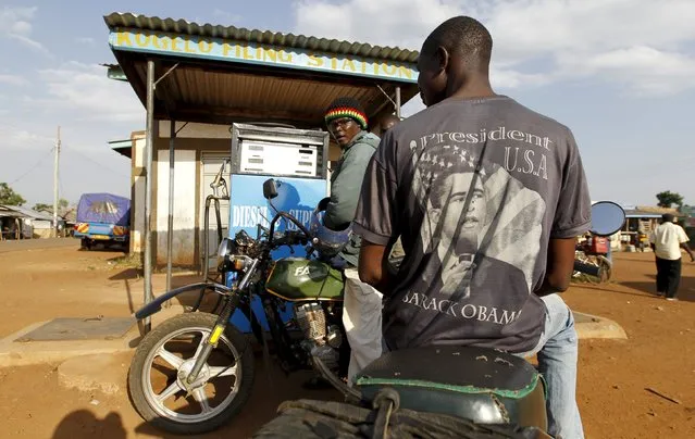 A motorcyclist wearing a T-shirt with the image of U.S. President Barack Obama waits for fuel at the trading centre in Kogelo, west of Kenya's capital Nairobi, July 15, 2015. U.S. President Barack Obama visits Kenya and Ethiopia later this month. His ancestral home of Kogelo is home to Sarah Hussein Obama, his step-grandmother. (Photo by Thomas Mukoya/Reuters)