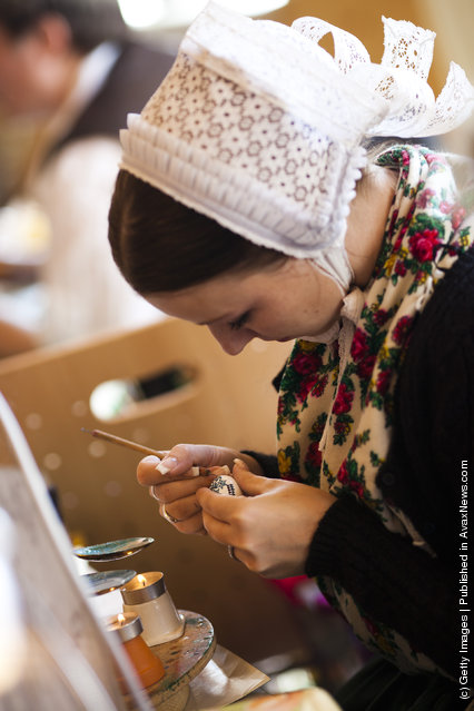 Melanie Baier from the village Obergurig wearing a traditional Lusatian sorbian folk dress, paints an Easter egg in traditional Sorbian motives at the annual Easter egg market