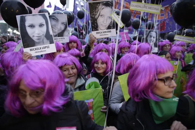 Demonstrators holding photos of victims of gender violence march outside the National Congress in Buenos Aires, Argentina, Friday, June 3, 2016. Thousands marched under the Spanish slogan #niunamenos, which in English means “not even one less”. Women's rights group Casa del Encuentro reports 275 femicides or gender-based killing of women in the past year. (Photo by Victor R. Caivano/AP Photo)