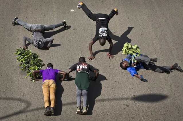 Demonstrators calling for the disbandment of the national electoral commission over allegations of bias and corruption, perform press-ups in the street as a sign of strength, in downtown Nairobi, Kenya Monday, June 6, 2016. (Photo by Ben Curtis/AP Photo)