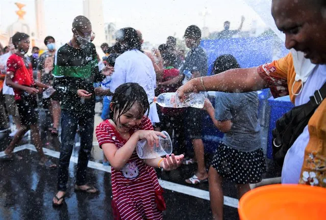 People play with water as they celebrate during the Songkran holiday which marks the Thai New Year during the coronavirus disease (COVID-19) outbreak, in Bangkok, Thailand, April 13, 2022. (Photo by Chalinee Thirasupa/Reuters)