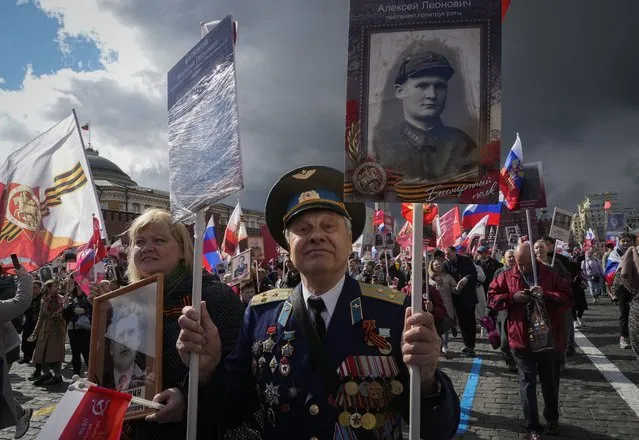 People attend the Immortal Regiment march through Red Square marking the 77th anniversary of the end of World War II, in Moscow, Russia, Monday, May 9, 2022. (Photo by Alexander Zemlianichenko/AP Photo)