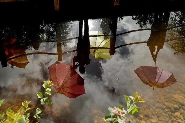 A dance troop are reflected in water as they pose for photographers on “The Thames Water Flourishing Future Garden” during a photocall at the press day for the RHS (Royal Horticultural Society) Hampton Court Palace Garden Festival in East Molesey, south west London, Monday, July 1, 2019. (Photo by Matt Dunham/AP Photo)