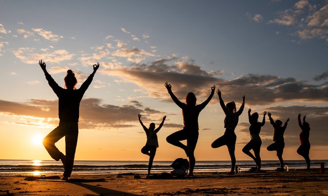 Members of the Happy Seal Yoga class practice on Cayton Bay in Scarborough, England’s North Sea coast as the sun rises to celebrate the Summer Solstice on Wednesday, June 21, 2023. (Photo by Danny Lawson/PA Images via Getty Images)