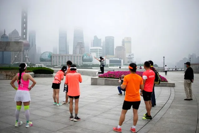 A woman poses for a jump shot on the Bund, in front of buildings in the Lujiazui financial district, after the lockdown placed to curb the coronavirus disease (COVID-19) outbreak was lifted in Shanghai, China on June 1, 2022. (Photo by Aly Song/Reuters)