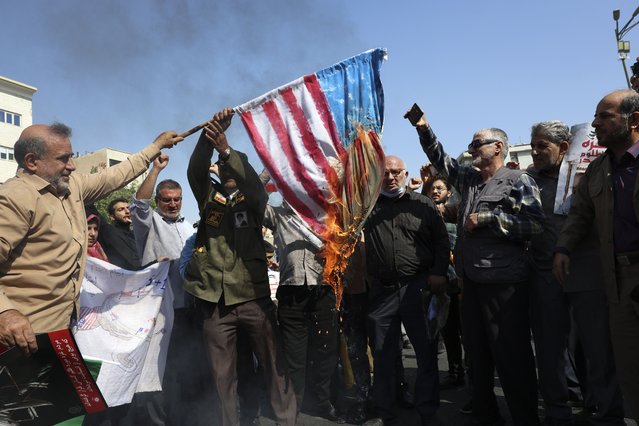 Iranian worshippers burn a representation of the U.S. flag during an anti-Israeli rally after Friday prayers in Tehran, Iran, Friday, September 27, 2024. (Photo by Vahid Salemi/AP Photo)