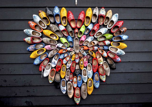 A heart is formed with Holland clogs at the windmills museum of Zaanse Schan in Zaandijk, Netherlands, Tuesday, August 15, 2023. The windmills were brought from from various places in the Netherlands to Zaandijk and are one of the country's most popular tourist hotspots. (Photo by Michael Probst/AP Photo)