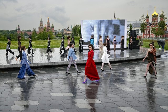 Models display a collection by a group of Russian designers of the Moscow Art-Industrial Institute, during the Fashion Week at Zaryadye Park with the Spasskaya Tower and St. Basil's Cathedral on the left in background near Red Square in Moscow, Russia, Tuesday, June 21, 2022. More than 100 shows are being held during the week that began Monday as well as scores of speakers who are noted names in the Russian fashion industry. (Photo by Alexander Zemlianichenko/AP Photo)