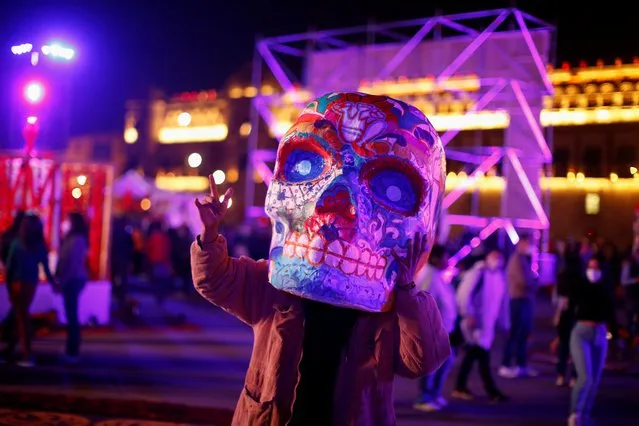 A person with a Catrina head gestures near Zocalo Square during the Day of the Dead celebration in Mexico City, Mexico, November 1, 2021. (Photo by Gustavo Graf/Reuters)