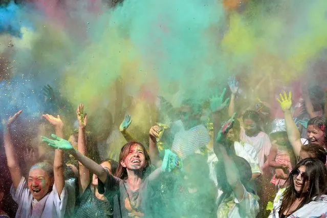 People throw coloured powder during the Holi Festival of Colours in Bishkek on July 3, 2022. Originally, the festival was celebrated in northern India by throwing colorful powers onto each other to celebrate Spring and drive away evil spirits. (Photo by Vyacheslav Oseledko/AFP Photo)