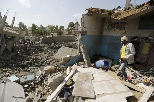 A man walks on the rubble of his house destroyed by Saudi-led air strikes on the nearby offices of the education ministry's workers union in Yemen's northwestern city of Amran August 19, 2015. (Photo by Khaled Abdullah/Reuters)