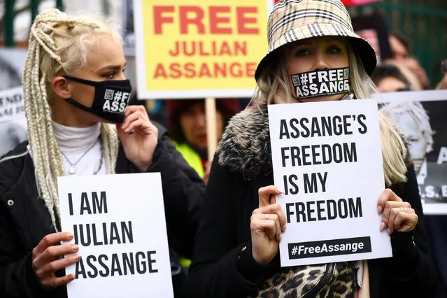Women, wearing face coverings with a hashtag of support for WikiLeaks founder Julian Assange, hold up signs outside Woolwich Crown Court, ahead of a hearing to decide whether Assange should be extradited to the United States, in London, Britain, February 24, 2020. (Photo by Hannah Mckay/Reuters)