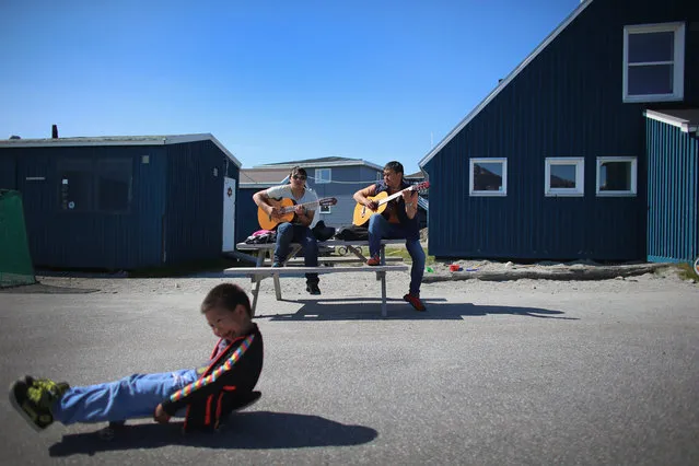 Karl Peter Jakobsen (L) and Miki Lange practice with their guitars as they enjoy a warm summer day on July 29, 2013 in Nuuk, Greenland. (Photo by Joe Raedle/Getty Images)