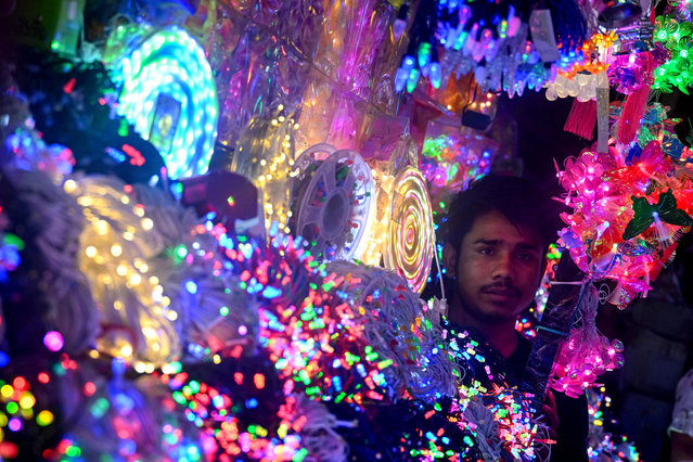 A shopkeeper sells decor and lights ahead of the Hindu festival of “Diwali”, in New Delhi on October 26, 2024. (Photo by Arun Sankar/AFP Photo)