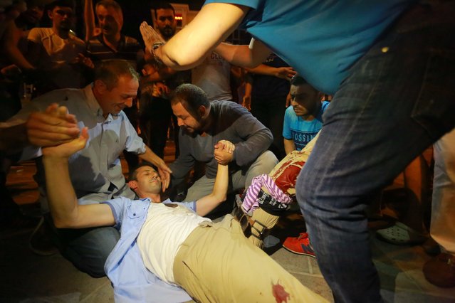 A wounded man is attended on a street in Istanbul, Turkey July 16, 2016. (Photo by Kemal Aslan/Reuters)