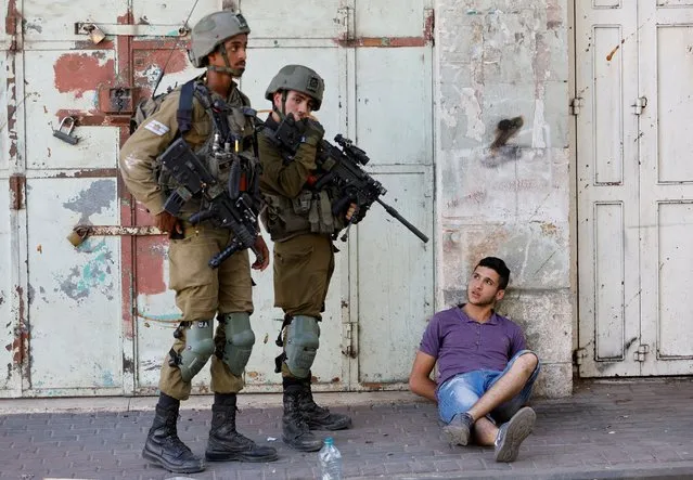 Israeli army soldiers detain a Palestinian during their clash with Palestinians, in Hebron in the Israeli-occupied West Bank on August 26, 2022. (Photo by Mussa Qawasma/Reuters)