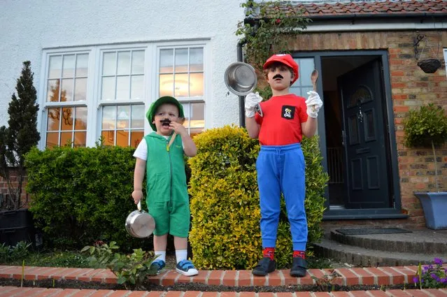 Brothers Luca (5) and Christian (2) dressed as Mario and Luigi during the Clap for our Carers campaign in support of the NHS as the spread of the coronavirus disease (COVID-19) continues, Cheshunt, Britain, April 16, 2020. (Photo by Mark Hartnell/Reuters)