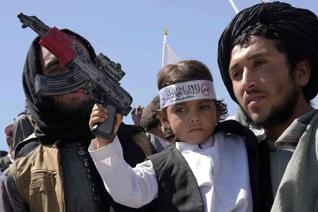 An Afghan boy holds a toy weapon during a celebration marking the first anniversary of the withdrawal of US-led troops from Afghanistan, in front of the U.S. Embassy in Kabul, Afghanistan, Wednesday, August 31, 2022. (Photo by Ebrahim Noroozi/AP Photo)