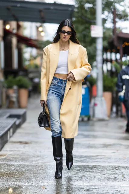 Kendall Jenner looks stylish while out in New York City on September 22, 2022. The American supermodel carried a Jimmy Choo bag and wore a yellow trench coat, crop top, jeans, and Jimmy Choo boots. (Photo by The Image Direct)