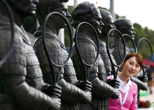 A woman looks at a statue of Roger Federer at Qizhong Forest Sports City Tennis Center where the Shanghai, on October 8, 2012. Masters tennis tournament is taking place in China. (Photo by Kin Cheung/Associated Press)