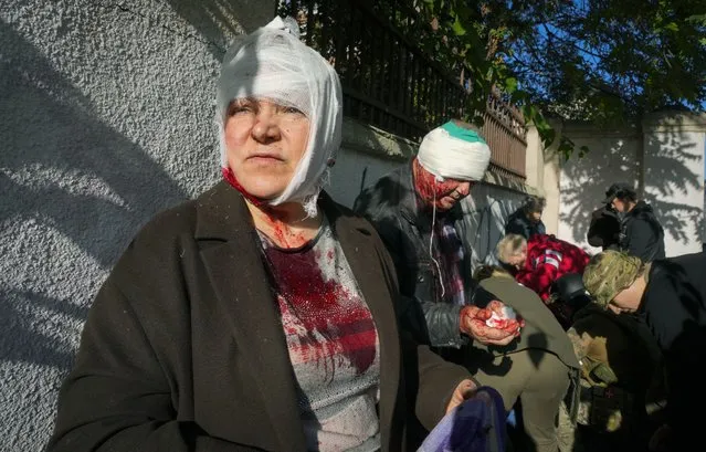 People receive medical treatment at the scene of Russian shelling, in Kyiv, Ukraine, Monday, October 10, 2022. Two explosions rocked Kyiv early Monday following months of relative calm in the Ukrainian capital. (Photo by Efrem Lukatsky/AP Photo)