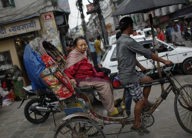 A Nepalese woman rides a rickshaw in Kathmandu, Nepal, Tuesday, September 15, 2015. The Himalayan nation is said to unveil its long-awaited new constitution on September 20, despite the ongoing protests by minority groups over the proposed federal structure, according to reports. (Photo by Niranjan Shrestha/AP Photo)
