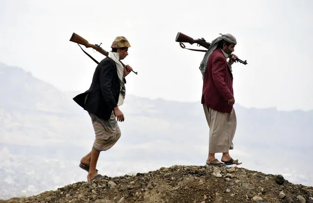 Members of the Shiite rebel militias walk atop a hill at the Al-Iman Sunni Islamic University which they seized control of it in Sana'a, Yemen, 29 September 2014.  Reports state the Shiite Houthi rebel movement still refuses to withdraw its militias from the capital Sana?a a week after the movement and the Yemeni Government signed a UN-brokered peace deal. (Photo by Yahya Arhab/EPA)