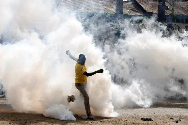 A man makes his way through rising tear gas fired by riot police officers to disperse supporters of Kenyan opposition leader Raila Odinga in Nairobi, Kenya on November 17, 2017. (Photo by Baz Ratner/Reuters)
