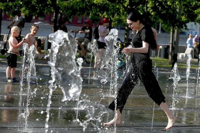 People cool off in a fountain at the Gorky Park as the temperature exceeds 30°C in Russian capital Moscow on June 11, 2020. The number of coronavirus cases in Russia exceeded half a million on Thursday. With 8,779 new infections confirmed over the last 24 hours, the tally rose to 502,436, the country's emergency task force said in a daily report. Over the same period, the virus claimed the lives of 174 people, raising the death toll to 6,532, it said. (Photo by Sefa Karacan/Anadolu Agency via Getty Images)