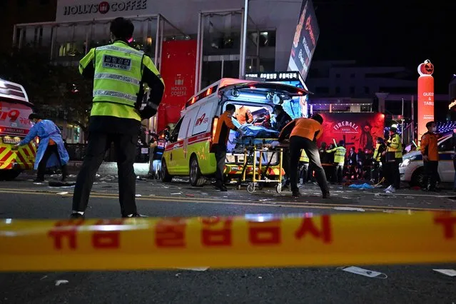 Medical staff attend to a person on a stretcher in the popular nightlife district of Itaewon in Seoul on October 30, 2022. (Photo by Jung Yeon-je/AFP Photo)