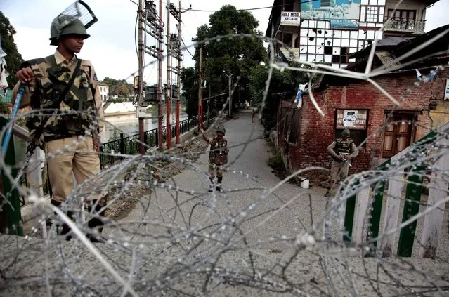 Indian paramilitary soldiers guard a checkpoint during curfew in Srinagar, Indian-controlled Kashmir, Monday, August 22, 2016. Security lockdown and protests continued with tens of thousands of Indian armed police and paramilitary soldiers patrolling the tense region after the killing of a popular rebel commander on July 8 sparked some of Kashmir's largest protests against Indian rule in recent years. (Photo by Mukhtar Khan/AP Photo)
