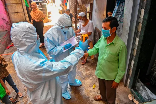 Medical staff wearing Personal Protective Equipment (PPE) gear conduct a door-to-door medical screening inside Dharavi slums to fight against the spread of the COVID-19 coronavirus, in Mumbai on June 24, 2020. The epidemic has badly hit India's densely populated major cities – including the national capital New Delhi and the financial hub Mumbai – with reports of hospitals being overwhelmed and patients struggling to find beds. (Photo by Indranil Mukherjee/AFP Photo)