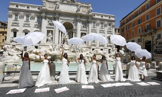 Women whose wedding ceremony was delayed or canceled due to restrictions caused by COVID-19 pandemic stage a protest at the Trevi Fountain in Rome, Tuesday, July 7, 2020. (Photo by Riccardo De Luca/AP Photo)