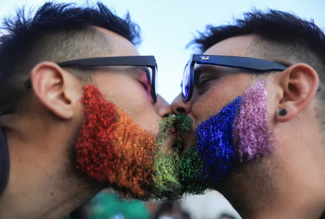 A couple kiss during the 31st LGBT Pride Parade in Buenos Aires, on November 5, 2022. A crowd participated on Saturday in Buenos Aires in the 31st LGBT Pride March, with streets and avenues filled and flagged with the colors of the rainbow, in an atmosphere of celebration, but also of claim for pending rights. (Photo by Reuters/Stringer)