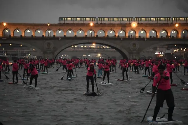 Amateurs and professionals take part in the Nautic Sup Paris crossing stand up paddle race along the Seine River in Paris on December 3, 2017. (Photo by Christophe Simon/AFP Photo)