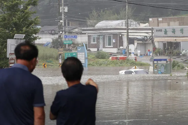 A vehicle is submerged in floodwaters following heavy rains in Paju, South Korea, Thursday, August 6, 2020. Torrential rains continuously pounded South Korea on Thursday, prompting authorities to close parts of highways and issue a rare flood alert near a key river bridge in Seoul. (Photo by Ahn Young-joon/AP Photo)