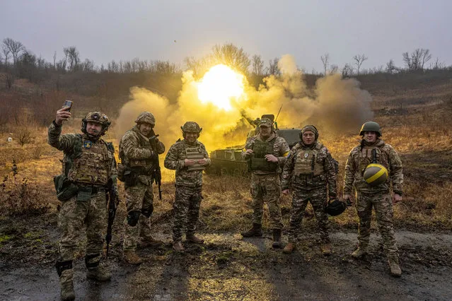 Ukrainian servicemen pose for a photo during the shoot towards Russian forces of self-propelled artillery at a frontline in Kharkiv region, Ukraine, Saturday, December 24, 2022. (Photo by Evgeniy Maloletka/AP Photo)