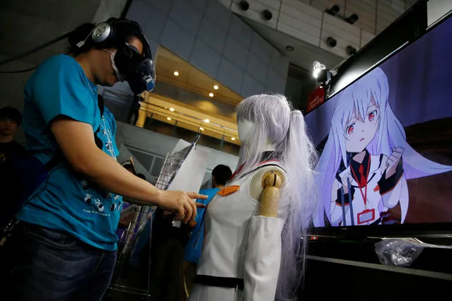 A man touches a mannequin as he tries out a M2 Co.Ltd's “E-mote” system and the monitor shows the image from the VR device at Tokyo Game Show 2016 in Chiba, east of Tokyo, Japan, September 15, 2016. “E-mote” is the abbreviation of “Emotional Motion Technology” and it is the tool of converting 2D image into 3D Look image without coding or other complicated procedures, the company said. (Photo by Kim Kyung-Hoon/Reuters)