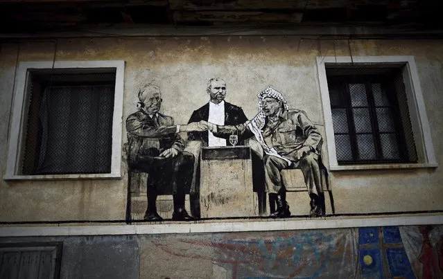 A photo made available on 31 August 2016 shows a mural depicting local man Vylka (C) with former President of Israel Shimon Peres (L) and former Palestinian leader Yasser Arafat (R), painted during a mural festival on a wall in the village of Staro Zhelezare some 14km from Sofia, Bulgaria, 30 August 2016. The project was initiated by the artistic duo Katarzyna and Ventzi Piryankova living permanently in Poznan, Poland. The festival is titled “Village of personalities / Art for Social Change”. The project started in 2013 and there have been created about 53 paintings in the village, representing local people in company of celebrities from politics and culture. (Photo by Vassil Donev/EFE)