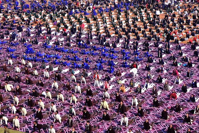 School students gather to practice yoga on the occasion of National Youth Day which is celebrated on the birth anniversary of Swami Vivekananda, an Indian Hindu monk, philosopher, author and religious teacher, at Ranital stadium on January 12, 2023. (Photo by Uma Shankar Mishra/AFP Photo)